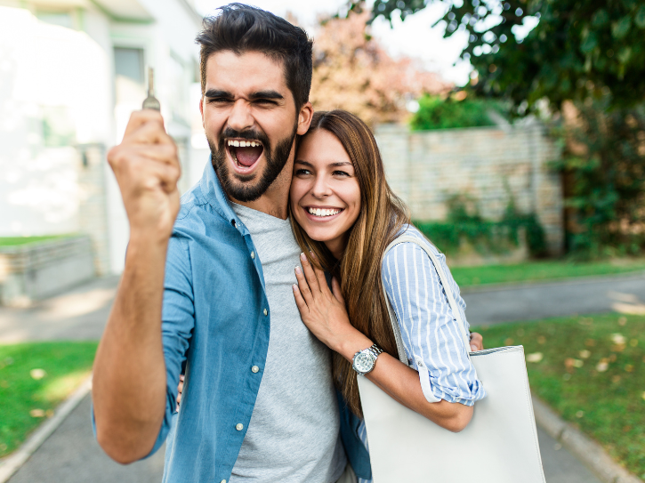 un couple qui tient une clef en main